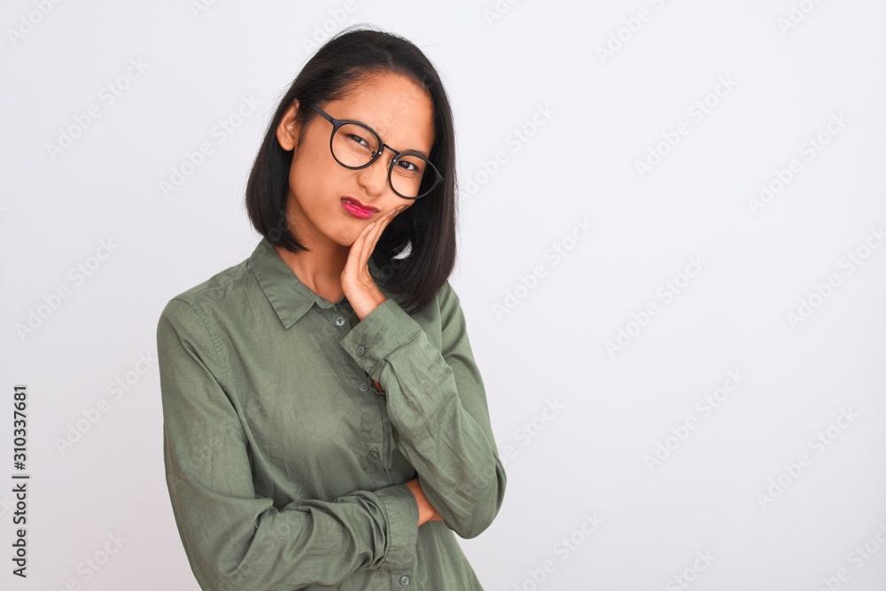 Young chinese woman wearing green shirt and glasses over isolated white background thinking looking tired and bored with depression problems with crossed arms. Young chinese woman wearing green shirt and glasses over isolated white background thinking looking tired and bored with depression problems with crossed arms.