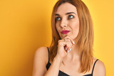 Close up of caucasian elegant woman over isolated yellow background serious face thinking about question, very confused idea
