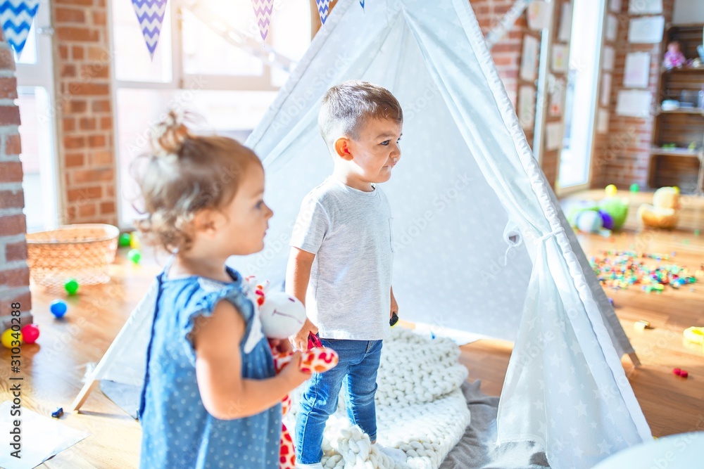 Obraz premium Adorable toddlers smiling happy. Standing playing around lots of toys at kindergarten