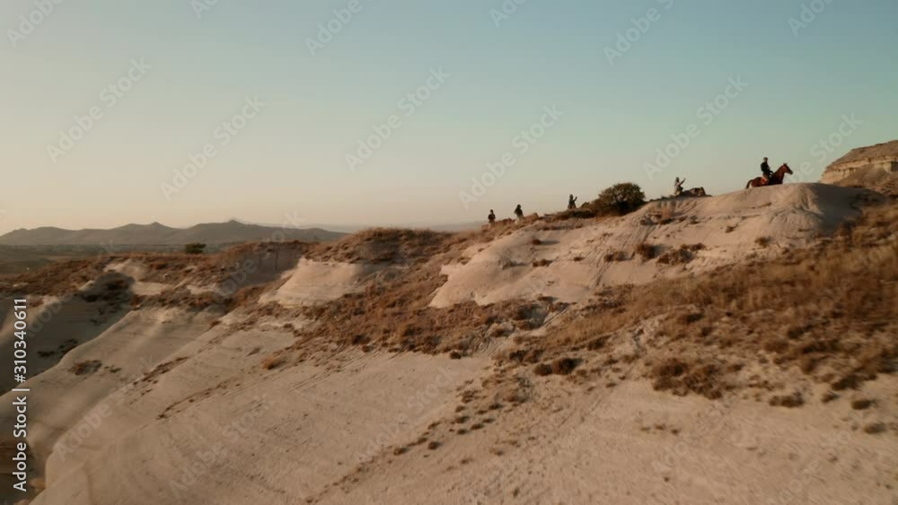Cappadocia, the setting sun and horses with riders, like a frame from the film Cappadocia, the setting sun and horses with riders, like a frame from the film