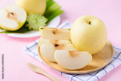 Sliced Asian pear fruit on wooden plate ready to eating