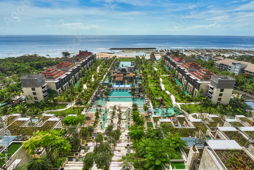 View on ocean beach and resort main areas with pool and garden from terace of luxury hotel