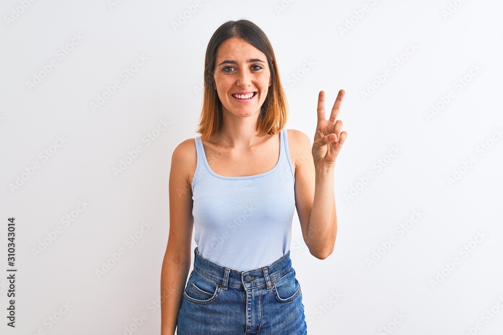 Beautiful redhead woman standing over isolated background showing and pointing up with fingers number two while smiling confident and happy. Beautiful redhead woman standing over isolated background showing and pointing up with fingers number two while smiling confident and happy.