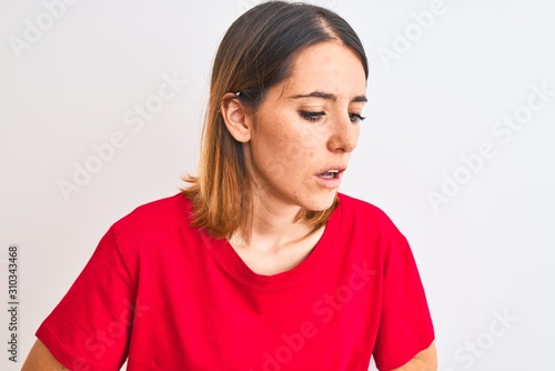 Beautiful redhead woman wearing casual red t-shirt over isolated background with hand on stomach because indigestion, painful illness feeling unwell. Ache concept. © Krakenimages.com