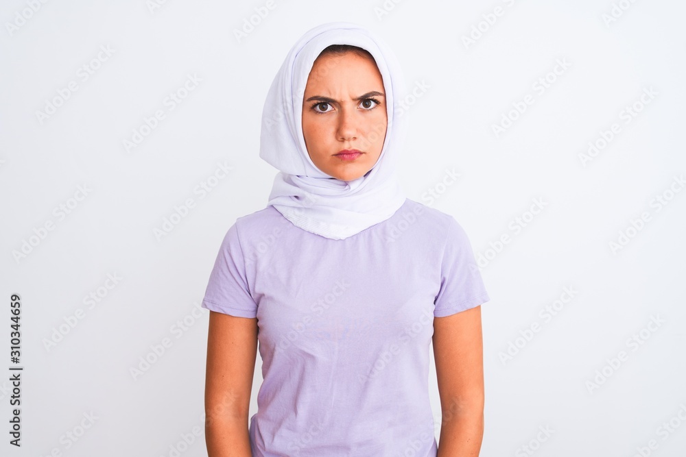 Young beautiful arabian girl wearing hijab standing over isolated white background skeptic and nervous, frowning upset because of problem. Negative person. Young beautiful arabian girl wearing hijab standing over isolated white background skeptic and nervous, frowning upset because of problem. Negative person.