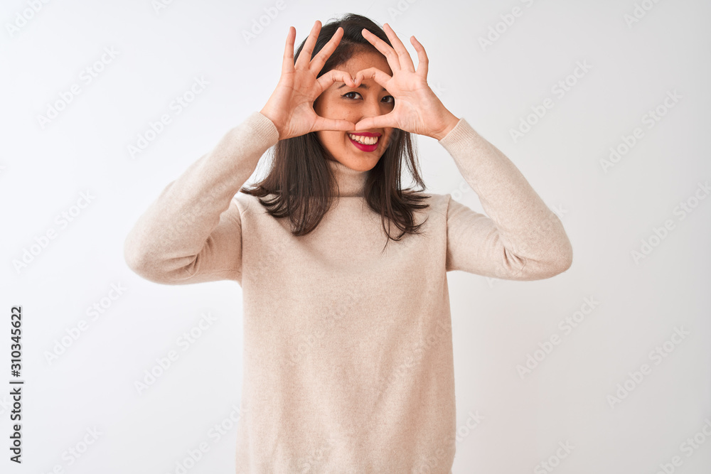 Beautiful chinese woman wearing turtleneck sweater standing over isolated white background Doing heart shape with hand and fingers smiling looking through sign Beautiful chinese woman wearing turtleneck sweater standing over isolated white background Doing heart shape with hand and fingers smiling looking through sign
