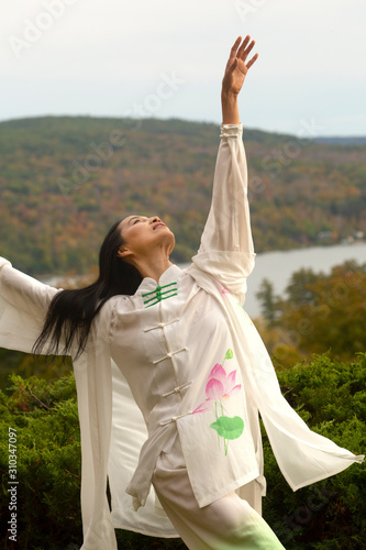 Woman dancing outdoors wearing a white cape in western Massachusetts. photo