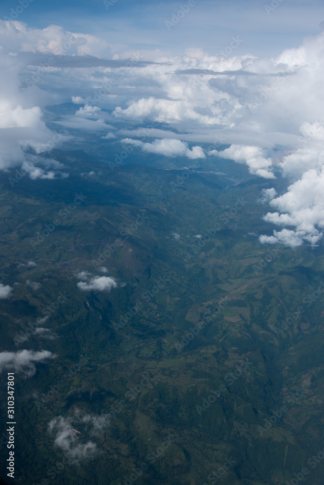 View from an airplane of Andean mountain ranges between clouds. Colombia