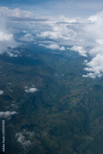 View from an airplane of Andean mountain ranges between clouds. Colombia