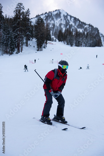 snowboarder enjoying skiing in mountains in the evening on the slope at winter ski resort