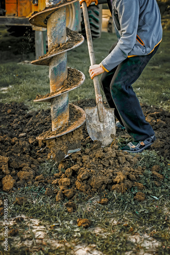 Photography Truck with drill auger drilling earth at the construction site
