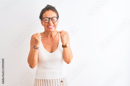 Middle age woman wearing casual t-shirt and glasses standing over isolated white background excited for success with arms raised and eyes closed celebrating victory smiling. Winner concept. © Krakenimages.com