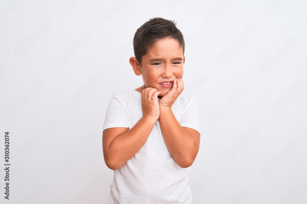 Beautiful kid boy wearing casual t-shirt standing over isolated white background touching mouth with hand with painful expression because of toothache or dental illness on teeth. Dentist concept. Beautiful kid boy wearing casual t-shirt standing over isolated white background touching mouth with hand with painful expression because of toothache or dental illness on teeth. Dentist concept.