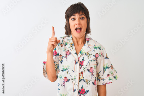 Beautiful woman on vacation wearing summer casual shirt over isolated white background pointing finger up with successful idea. Exited and happy. Number one.