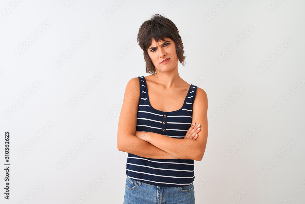 Young beautiful woman wearing striped t-shirt standing over isolated white background skeptic and nervous, disapproving expression on face with crossed arms. Negative person. Young beautiful woman wearing striped t-shirt standing over isolated white background skeptic and nervous, disapproving expression on face with crossed arms. Negative person.