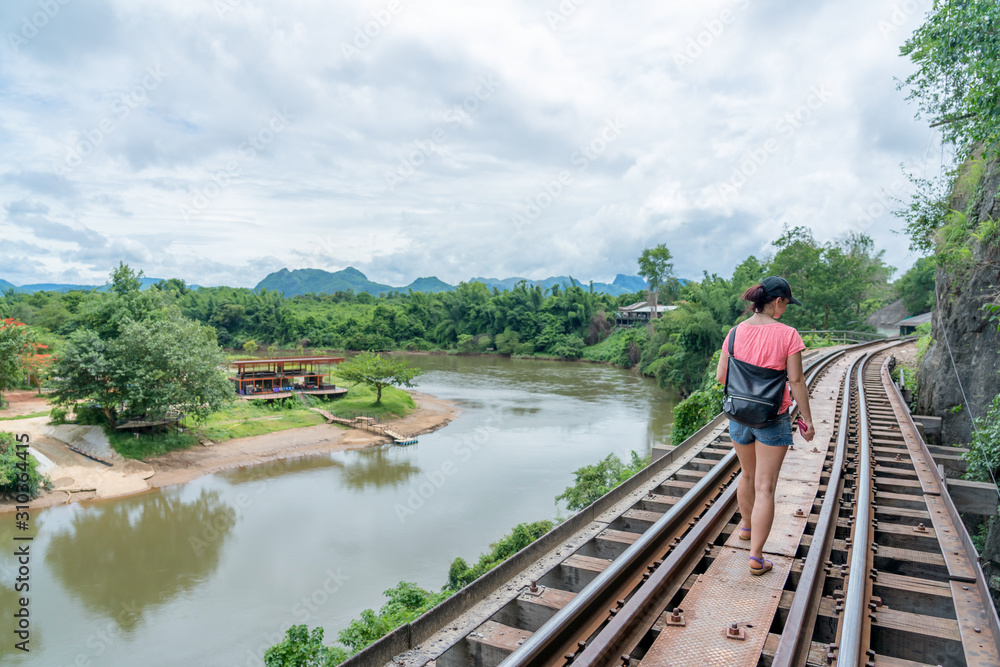 young cute hipster girl travelling at beautiful sky mountains scenery park hiking garden views at Kanchanaburi Thailand guiding idea for female backpacker woman women backpacking