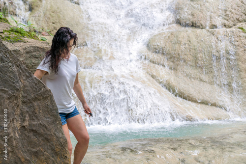 young cute hipster girl travelling at beautiful Erawan waterfall mountains  green forest hiking views at Kanchanaburi  Thailand. guiding  idea for female backpacker woman women backpacking