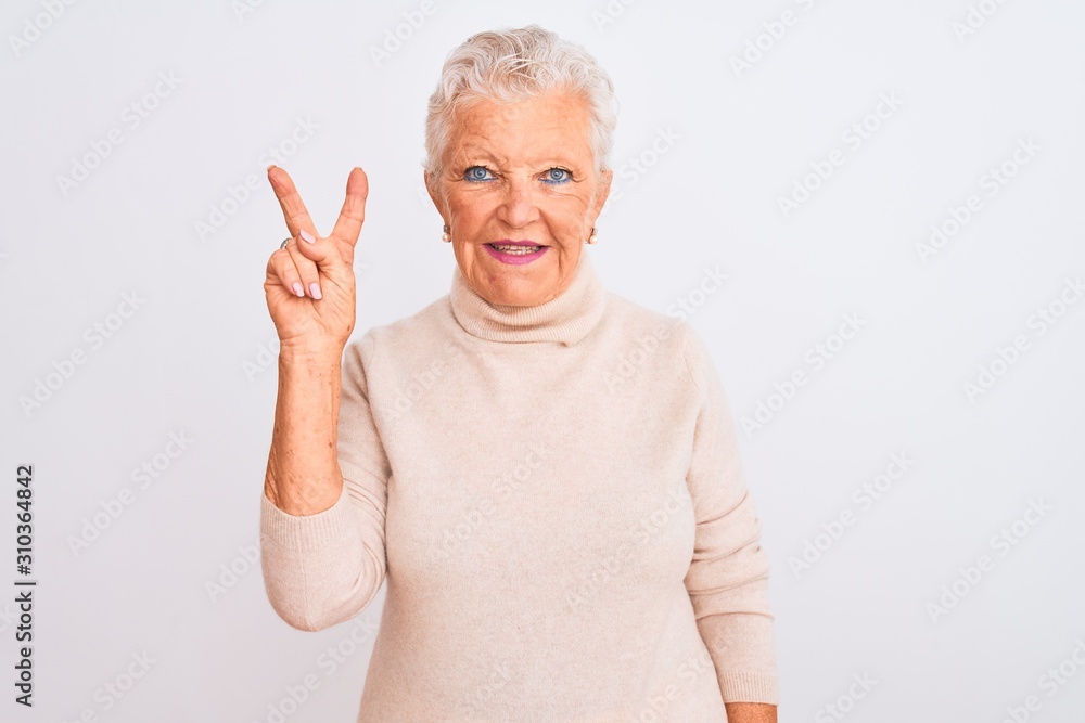 Senior grey-haired woman wearing turtleneck sweater standing over isolated white background showing and pointing up with fingers number two while smiling confident and happy. Senior grey-haired woman wearing turtleneck sweater standing over isolated white background showing and pointing up with fingers number two while smiling confident and happy.