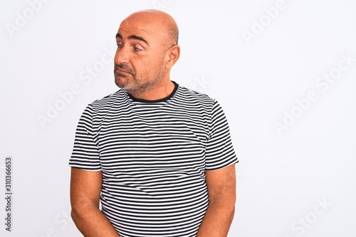 Middle age handsome man wearing striped navy t-shirt over isolated white background smiling looking to the side and staring away thinking.