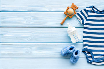 Baby background - blue color. Clothes and accessories for newborn boy on blue wooden table top-down frame copy space