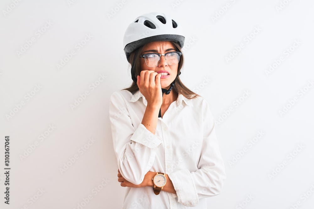 Beautiful businesswoman wearing glasses and bike helmet over isolated white background looking stressed and nervous with hands on mouth biting nails. Anxiety problem. Beautiful businesswoman wearing glasses and bike helmet over isolated white background looking stressed and nervous with hands on mouth biting nails. Anxiety problem.