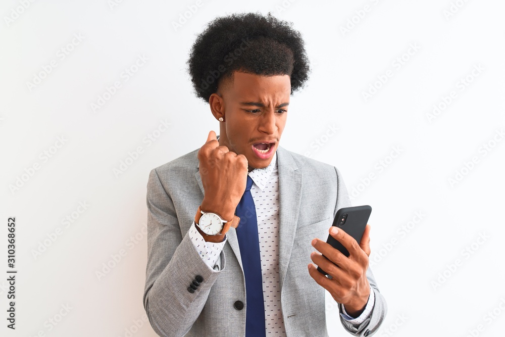 Young african american businessman using smartphone over isolated white background annoyed and frustrated shouting with anger, crazy and yelling with raised hand, anger concept Young african american businessman using smartphone over isolated white background annoyed and frustrated shouting with anger, crazy and yelling with raised hand, anger concept