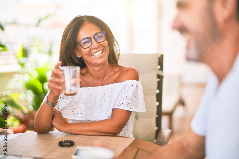 Middle age beautiful couple sitting on terrace drinking cup of coffe Middle age beautiful couple sitting on terrace drinking cup of coffe