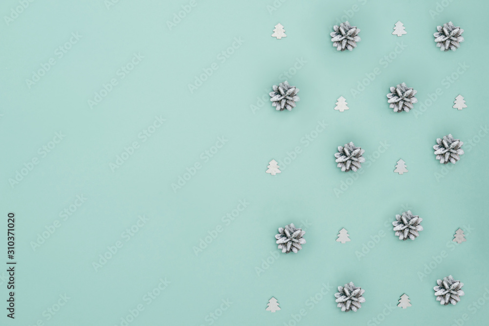 Silver Christmas trees and tree cones on mint backdrop. Christmas and new year concept. Flat lay style. Place for text. Silver Christmas trees and tree cones on mint backdrop. Christmas and new year concept. Flat lay style. Place for text.