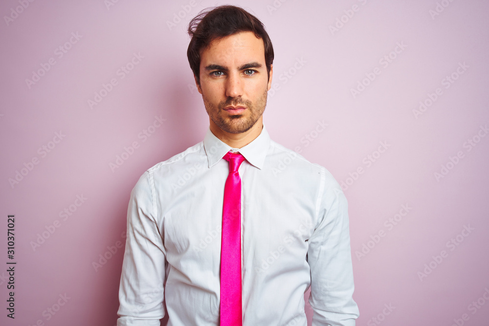 Φωτογραφία Young handsome businessman wearing shirt and tie standing over isolated pink background with serious expression on face
