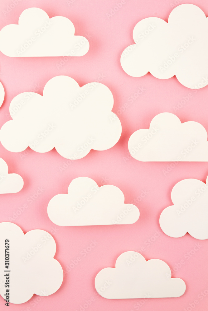 White paper cut out clouds over pink background.