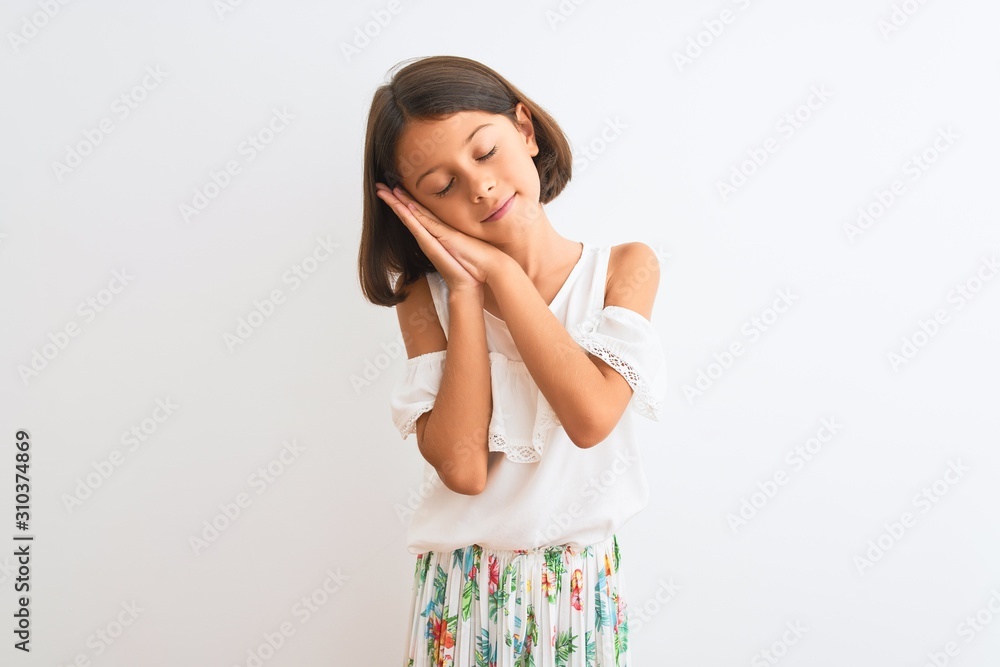 Young beautiful child girl wearing casual dress standing over isolated white background sleeping tired dreaming and posing with hands together while smiling with closed eyes. Young beautiful child girl wearing casual dress standing over isolated white background sleeping tired dreaming and posing with hands together while smiling with closed eyes.