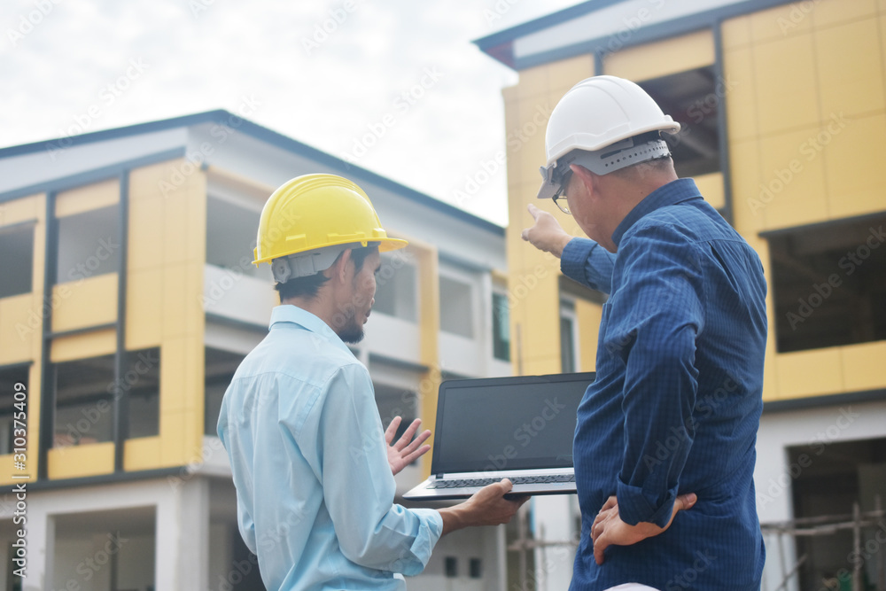 Two Engineering use computer notebook presentation at work place building estate construction background Two Engineering use computer notebook presentation at work place building estate construction background