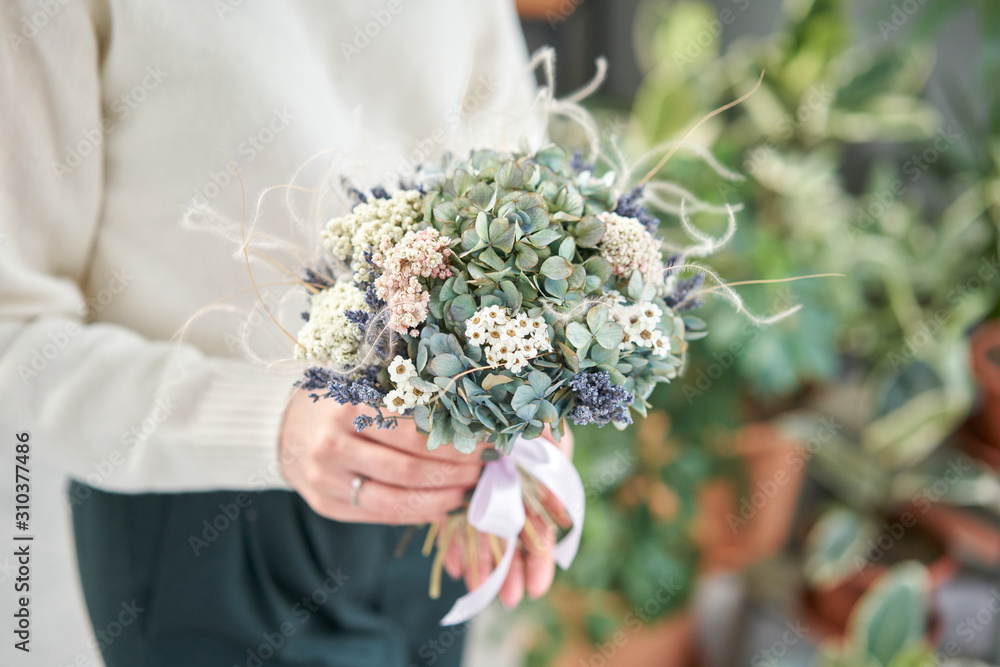 Colourful beautiful bouquet of mixed dried flowers in woman hand. the work of the florist at a flower shop. Colourful beautiful bouquet of mixed dried flowers in woman hand. the work of the florist at a flower shop.