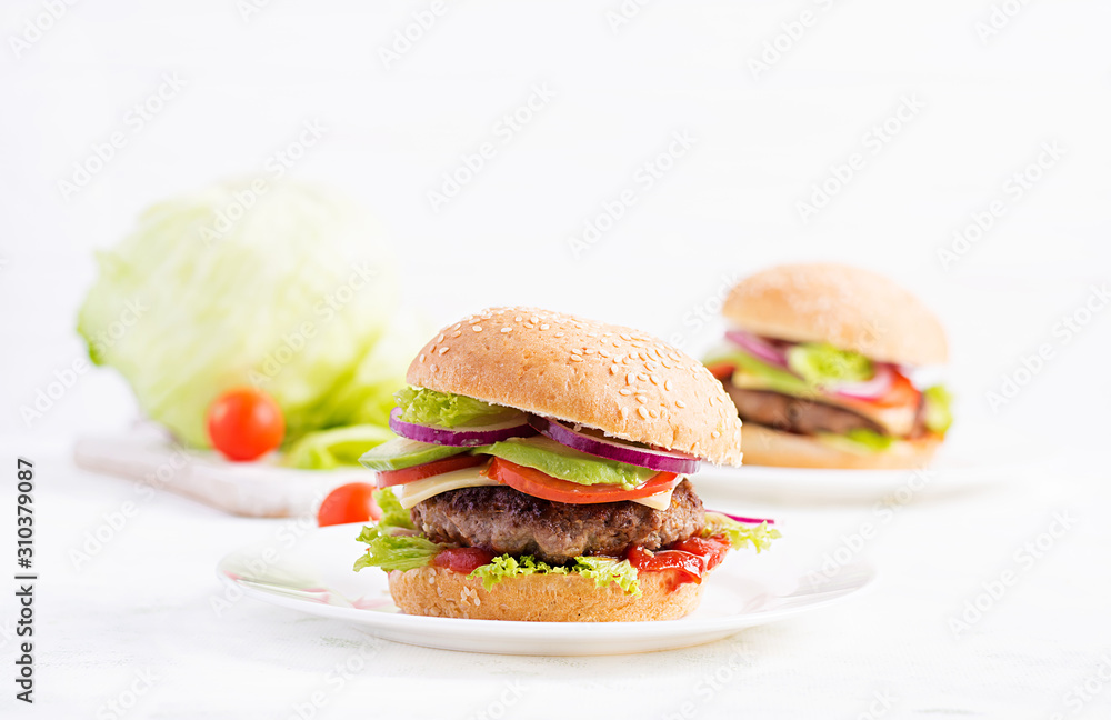 Big sandwich - hamburger burger with beef, avocado, tomato and red onions on light background. American cuisine. Fast Food Big sandwich - hamburger burger with beef, avocado, tomato and red onions on light background. American cuisine. Fast Food