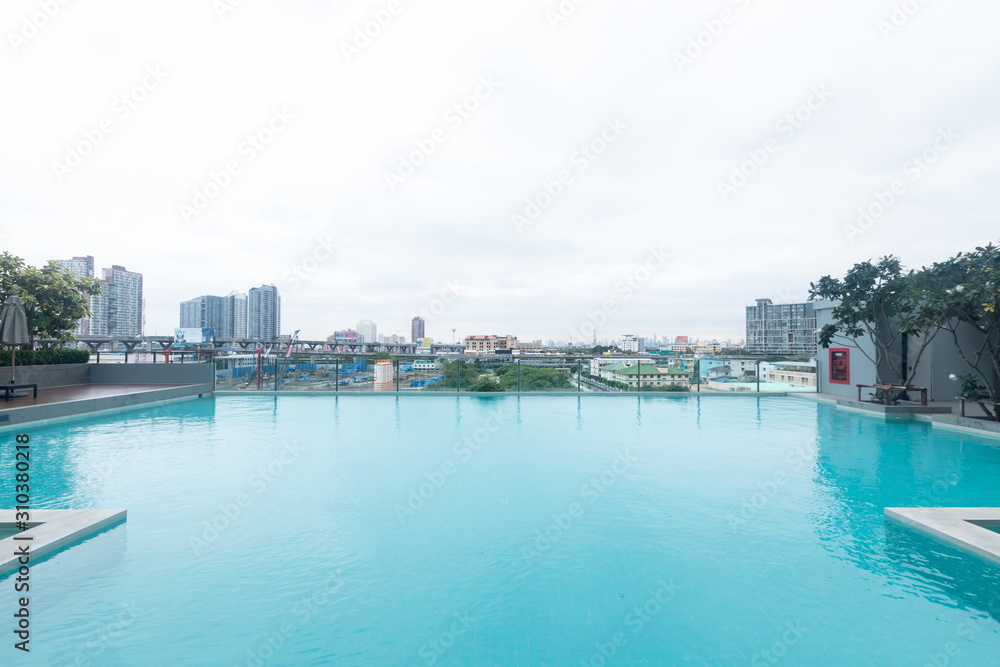 swimming pool blue water and cityscape view with high tower building .