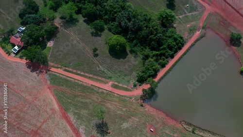 Aerial shot over a farming area of Brazil with roads, cultives and a pond. photo