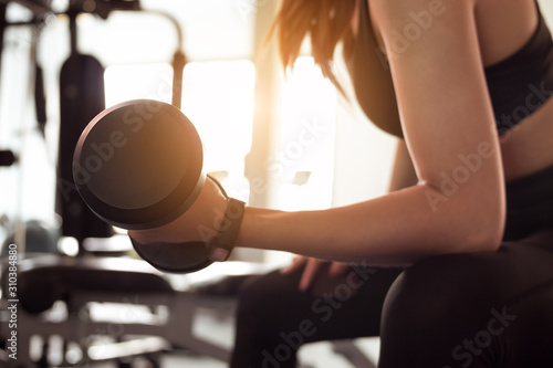 Woman doing exercise workout dumbbell at fitness gym. lifestyle and exercise concept.