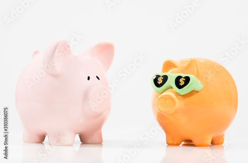 Concept image image for saving featuring two piggy banks one of which appears to be more successful. 