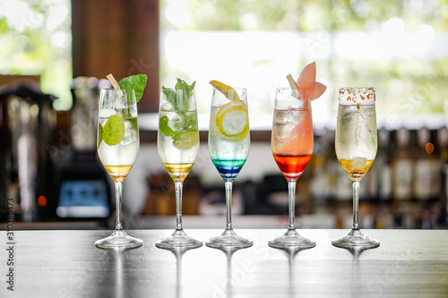 Colorful cocktails are lined up on the bar table.