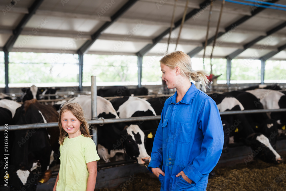 Woman with daughter in cowshed Woman with daughter in cowshed