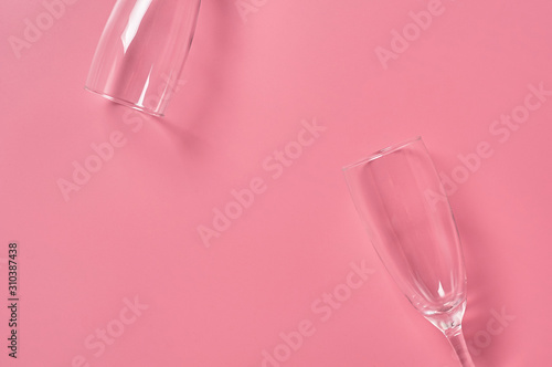 Two glasses for champagne lies on pink table on kitchen. Concept of celebrating. Space for text. Top view