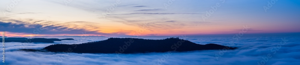 Germany, XXL panorama aerial view above fog clouds in valley of swabian jura nature landscape at sunset near stuttgart on mountain breitenstein with view to castle teck Germany, XXL panorama aerial view above fog clouds in valley of swabian jura nature landscape at sunset near stuttgart on mountain breitenstein with view to castle teck