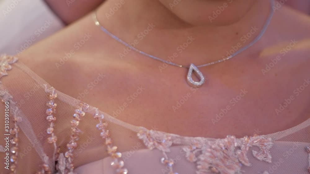 Men's hands put beautiful pendant on girl’s neck. Slow motion and close-up Men's hands put beautiful pendant on girl’s neck. Slow motion and close-up