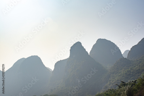 Karst formation and foggy limestone mountain landscape between Guiling and Yangshuo, Guangxi province, China photo