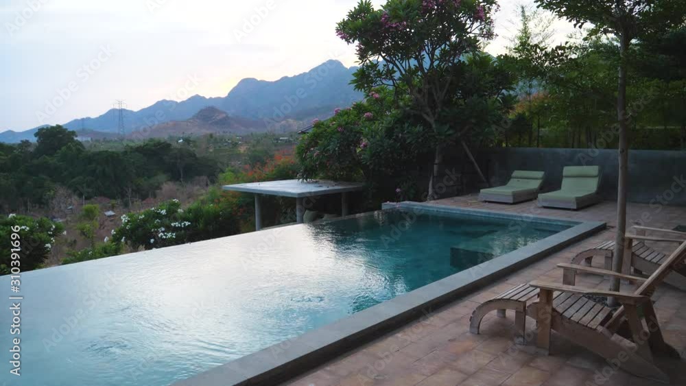 Spa resort and pool with water moving slowly and wooden loungers for relaxing and enjoying in peaceful nature Spa resort and pool with water moving slowly and wooden loungers for relaxing and enjoying in peaceful nature