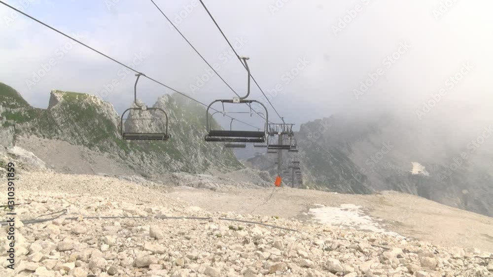 Empty moving chairlift in foggy mountains in summer, static shot. Empty moving chairlift in foggy mountains in summer, static shot.
