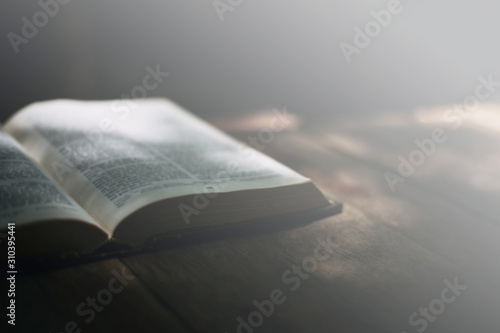 Soft focus Open holy bible on wood table with copy space.