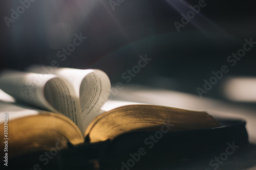 Soft focus open holy Bible at window,heart pages background