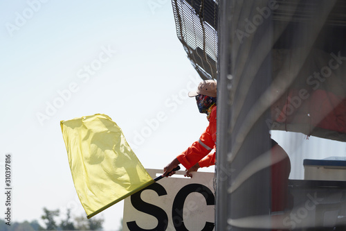 Canvastavla A man in yellow bogong on the racetrack.