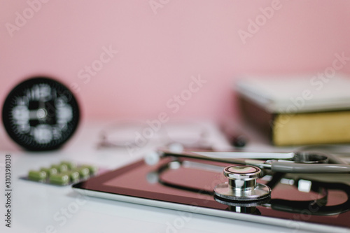 Selective focus Stethoscope and Tablet on pink desk.concept of Doctor table